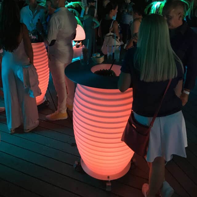 table debout illuminée comprenant un refroidisseur de vin lors d'une fête sur la plage