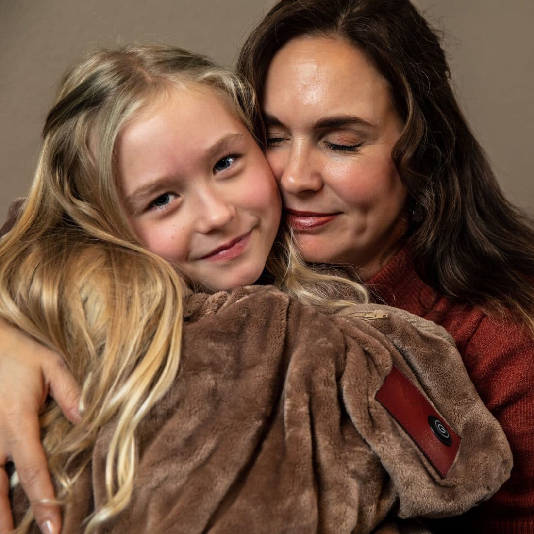 moeder en dochter samen onder een zachte infrarood warmtedeken in de kleur taupe